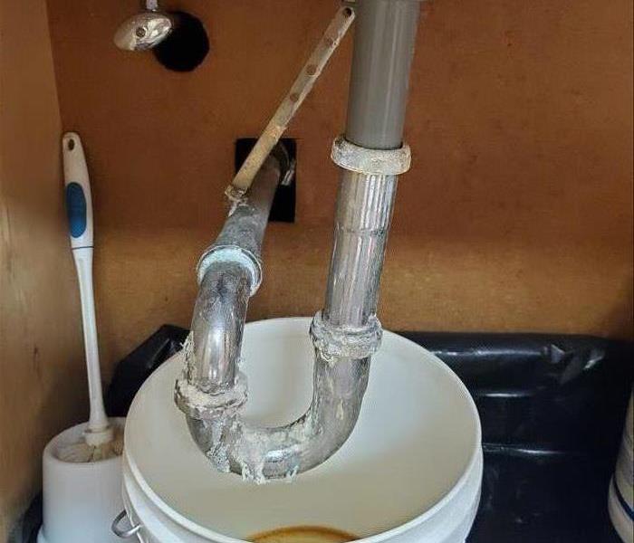 A Dripping Pipe Under the Sink with a Shutoff Valve